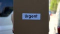 Urgent delivery courier in uniform holding cardboard box, international shipping