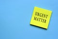 Urgent matter text on yellow sticky note Royalty Free Stock Photo