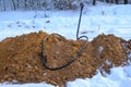 Urgent repairs during the winter. Electric cable replacement. A pile of sand, a cable and a shovel for digging the