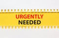 Urgently needed symbol. Concept words Urgently needed on yellow paper on a beautiful white background. Business and urgently