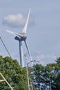 Urk, The Netherlands - June 15 2020 Windmills on the coast with trees, mast and birds moving. Wind power and Green