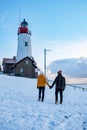 Urk Netherlands lighthouse during winter with snow covered coastline, Urk view at the lighthouse snowy landscape winter Royalty Free Stock Photo