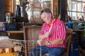 Man in traditional Dutch costume mending fishing nets in workshop