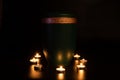 GREEN URNA WITH GOLDEN EDGE surrounded with small burning candles