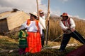 The Uros indigenous family help to unmoor the traditional boat made of totora reeds