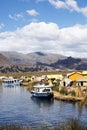 Uros, Peru - Jan 5, 2019. Traditional Totora boat with tourists on Titicaca lake near to the Uros floating islands , Puno, Peru, Royalty Free Stock Photo