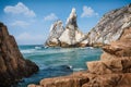 Ursa beach, Sintra, Portugal. Epic seascape of cliffs towering up from emerald green atlantic ocean. White clouds on