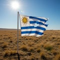 Uruguay\'s flag waves in an open plain under a clear blue sky. The flag features Royalty Free Stock Photo