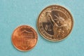 US American coins lie on a light blue cardboard background. Denomination: 1 dollar and 1 cent. Reverse. National or reserve