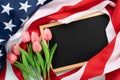 US American flag with blackboard and tulip flower on blue wooden background. For USA Memorial day, Presidents day, Veterans day, Royalty Free Stock Photo