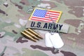 US ARMY branch tape with dog tag flag patch and 5.56 mm rounds on camouflage uniform Royalty Free Stock Photo