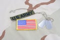 US ARMY branch tape with dog tags and flag patch on desert camouflage uniform Royalty Free Stock Photo