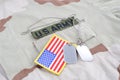 US ARMY branch tape with dog tags and flag patch on desert camouflage uniform Royalty Free Stock Photo