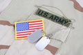 US ARMY branch tape with dog tags and flag patch on desert camouflage uniform Royalty Free Stock Photo