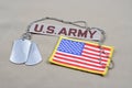 US ARMY branch tape with dog tags and US flag patch on desert camouflage uniform Royalty Free Stock Photo