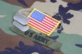 US ARMY branch tape, flag patch and dog tags on woodland camouflage uniform Royalty Free Stock Photo