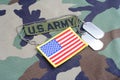 US ARMY branch tape, flag patch and dog tags on woodland camouflage uniform Royalty Free Stock Photo