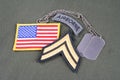 US ARMY Corporal rank patch, airborne tab, flag patch and dog tag on olive green uniform Royalty Free Stock Photo