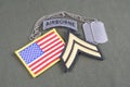 US ARMY Corporal rank patch, airborne tab, flag patch and dog tag on olive green uniform