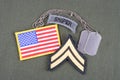 US ARMY Corporal rank patch, sniper tab, flag patch and dog tag on olive green uniform