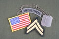 US ARMY Corporal rank patch, special forces tab, flag patch and dog tag on olive green uniform