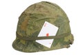 US Army helmet Vietnam war period with camouflage cover and ammo belt and amulet playing card ace of diamonds Royalty Free Stock Photo