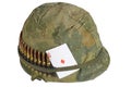 US Army helmet Vietnam war period with camouflage cover, ammo belt and amulet playing card ace of diamonds Royalty Free Stock Photo