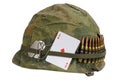 US Army helmet Vietnam war period with camouflage cover and ammo belt, dog tag and amulet playing card ace of diamonds Royalty Free Stock Photo