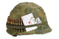 US Army helmet Vietnam war period with camouflage cover and ammo belt, dog tag and amulet playing card ace of diamonds Royalty Free Stock Photo