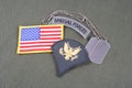 US ARMY Specialist rank patch, special forces tab, flag patch and dog tag on olive green uniform