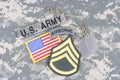 US ARMY Staff Sergeant rank patch, airborne tab, flag patch, with dog tag on camouflage uniform