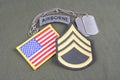 US ARMY Staff Sergeant rank patch, airborne tab, flag patch and dog tag on olive green uniform