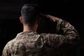 Young soldier saluting standing on black background Royalty Free Stock Photo