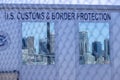 US Customs & Border Protection behind Chain Link Fence with US city reflected in windows Royalty Free Stock Photo