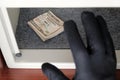 US dollar bills in a safe deposit box. A black gloved hand reaches for the money. The concept of saving money in a hotel or bank, Royalty Free Stock Photo