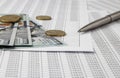 Side view of a silver pen that lies on a paper with numbers, next to the US dollar money. and the coin is cent. Banking, Royalty Free Stock Photo