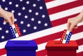 Hand holding and putting voting paper card in ballot voting box with USA flag in background. Royalty Free Stock Photo