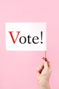 US elections, voting concept. Woman holding flag on a pink background