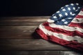 US flag draped across a dark wooden table, set against a dark background