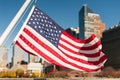 US flag floating with New-York city buildings in the background