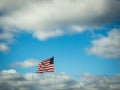 US Flag Flying in Blue, Cloudy Sky Royalty Free Stock Photo