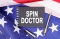The US flag has a pen and a notebook with the inscription - SPIN DOCTOR