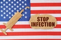 On the US flag there is a cardboard figure of a syringe and a torn cardboard with the inscription - STOP INFECTION