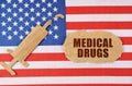 On the US flag there is a cardboard figure of a syringe and a torn cardboard with the inscription - MEDICAL DRUGS