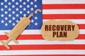 On the US flag there is a cardboard figure of a syringe and a torn cardboard with the inscription - RECOVERY PLAN