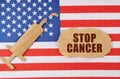 On the US flag there is a cardboard figure of a syringe and a torn cardboard with the inscription - STOP CANCER