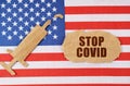 On the US flag there is a cardboard figure of a syringe and a torn cardboard with the inscription - STOP COVID