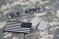 US IR flag patch with dog tags and US ARMY branch tape on camouflage army uniform Royalty Free Stock Photo