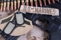 US MARINES branch tape with dog tags, ammunition belt and rifle on desert camouflage uniform