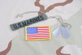 US MARINES branch tape with dog tags and flag patch on desert camouflage uniform Royalty Free Stock Photo